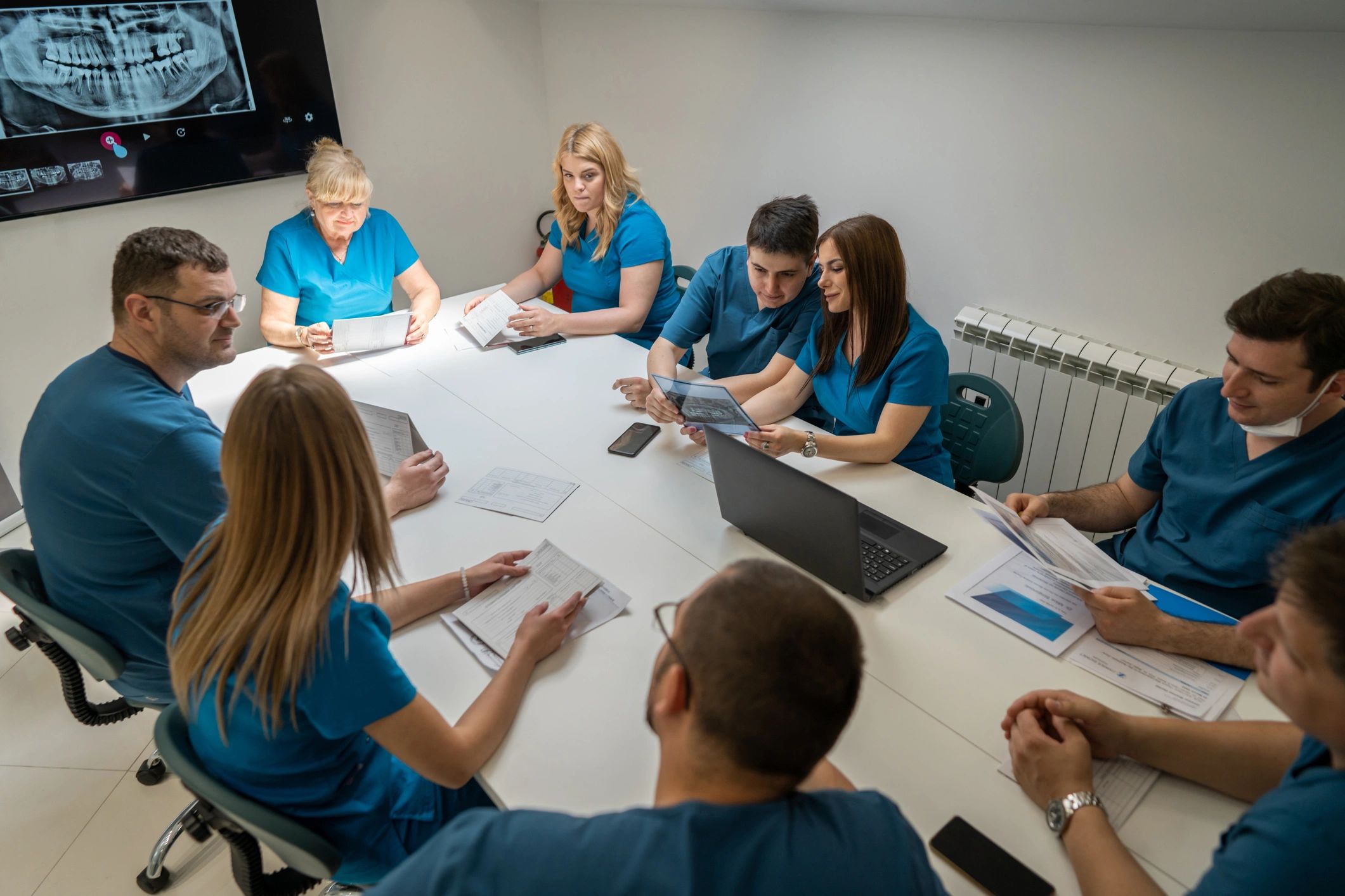 Dental team meeting in a clinic reviewing training materials